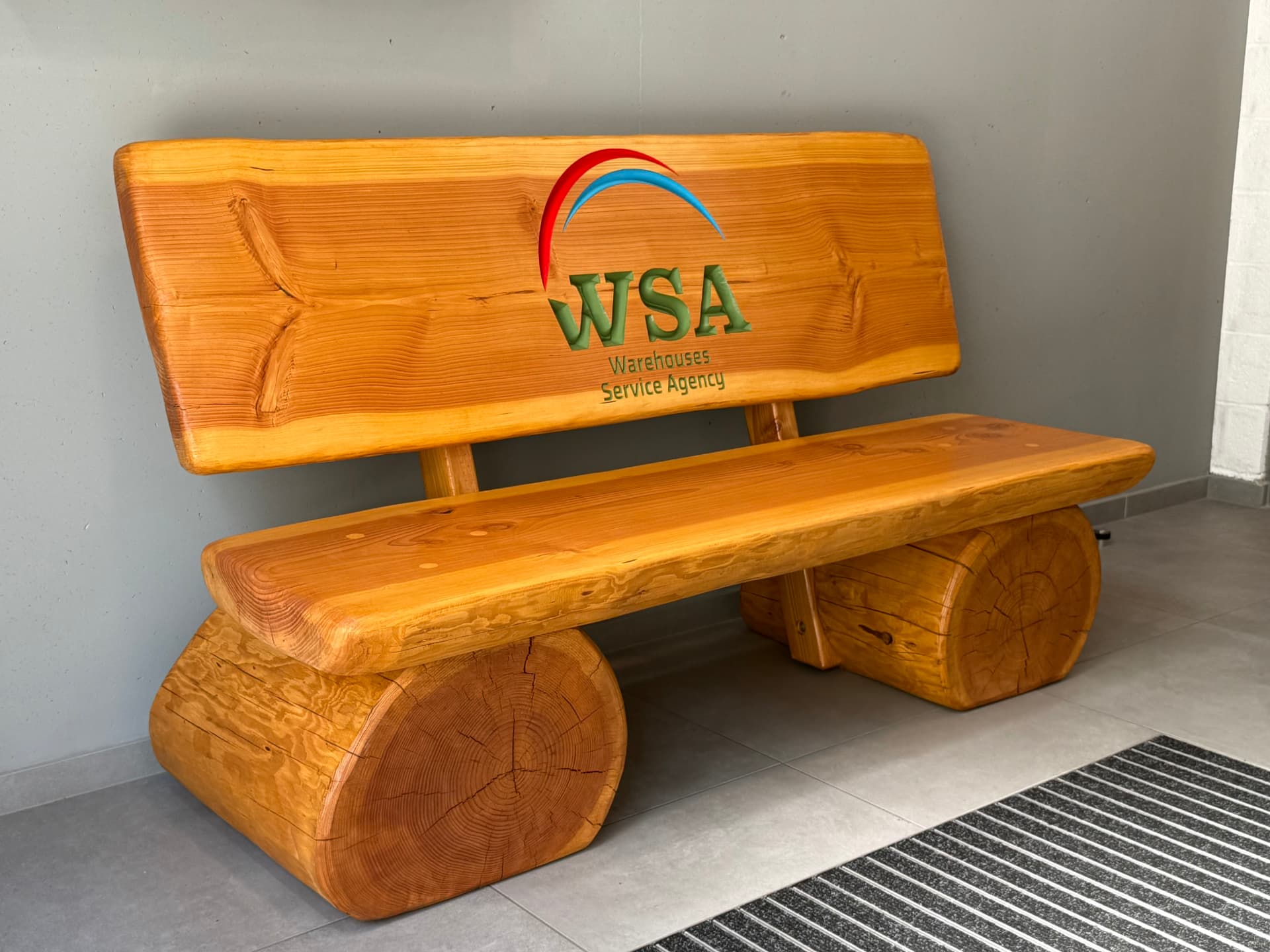 Massive Holzbank mit individueller CNC-Gravur und farbig ausgearbeitetem WSA-Firmenlogo, gefertigt von Holz Kreativ als personalisierte Sitzbank für Unternehmen