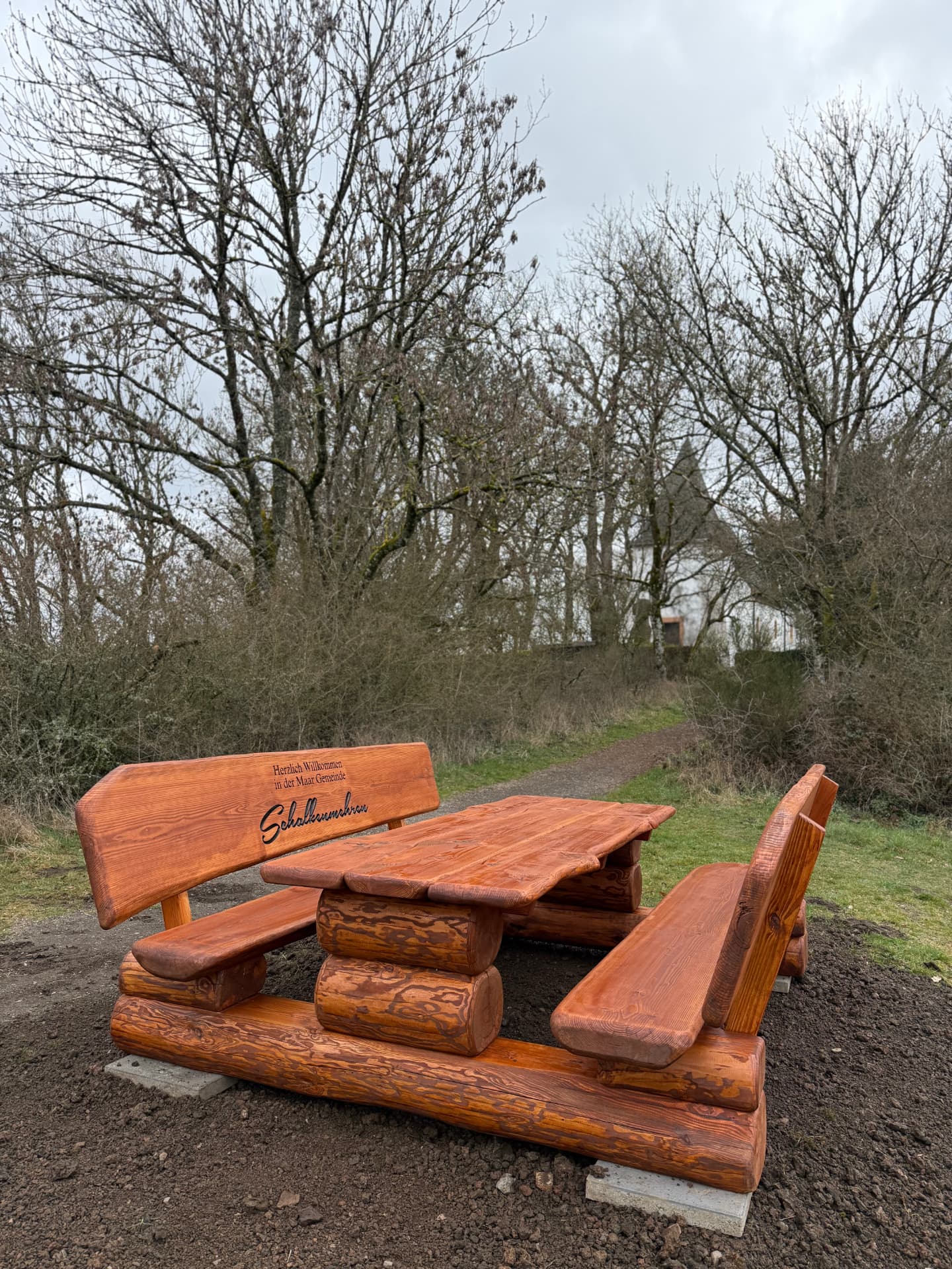 Massive Sitzgruppe aus Holz mit individueller Gravur für die Gemeinde Schalkenmehren als öffentlicher Sitz- und Rastplatz.
